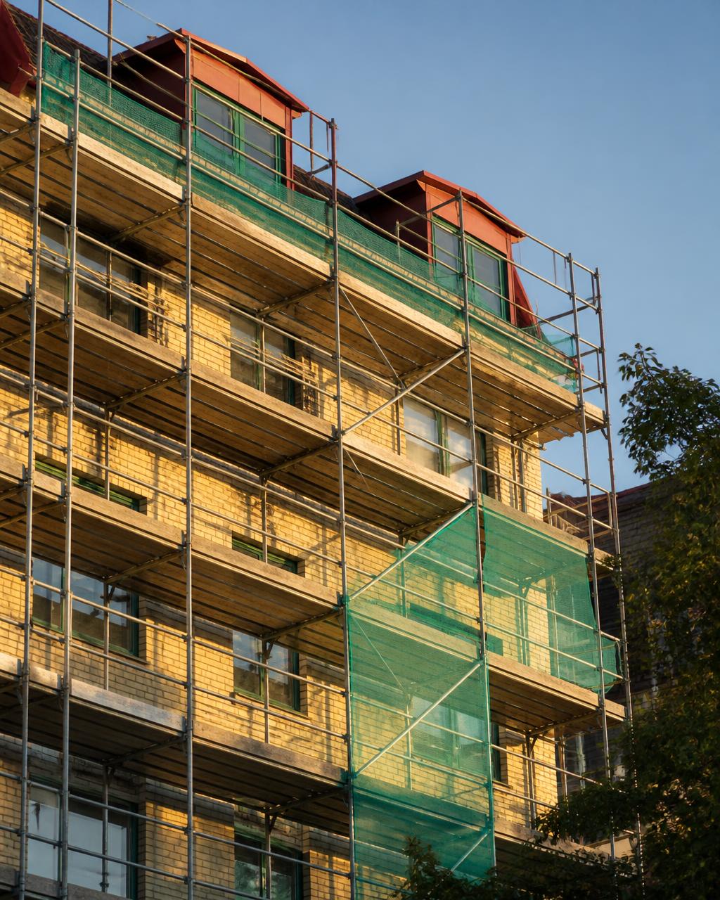 Byggnadsställning uppsatt längs en fasad under renovering i Borås